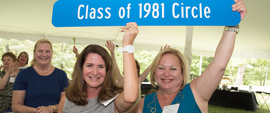 Two women holding up a "Class of 1981 Circle" sign