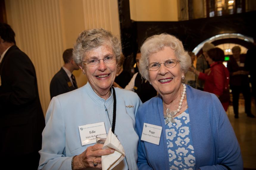 Two guests smile at event