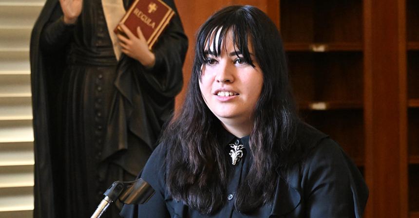 Student stands at a podium for a presentation