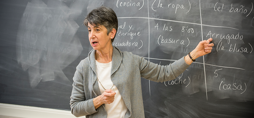 Teacher speaking and pointing to a chalkboard