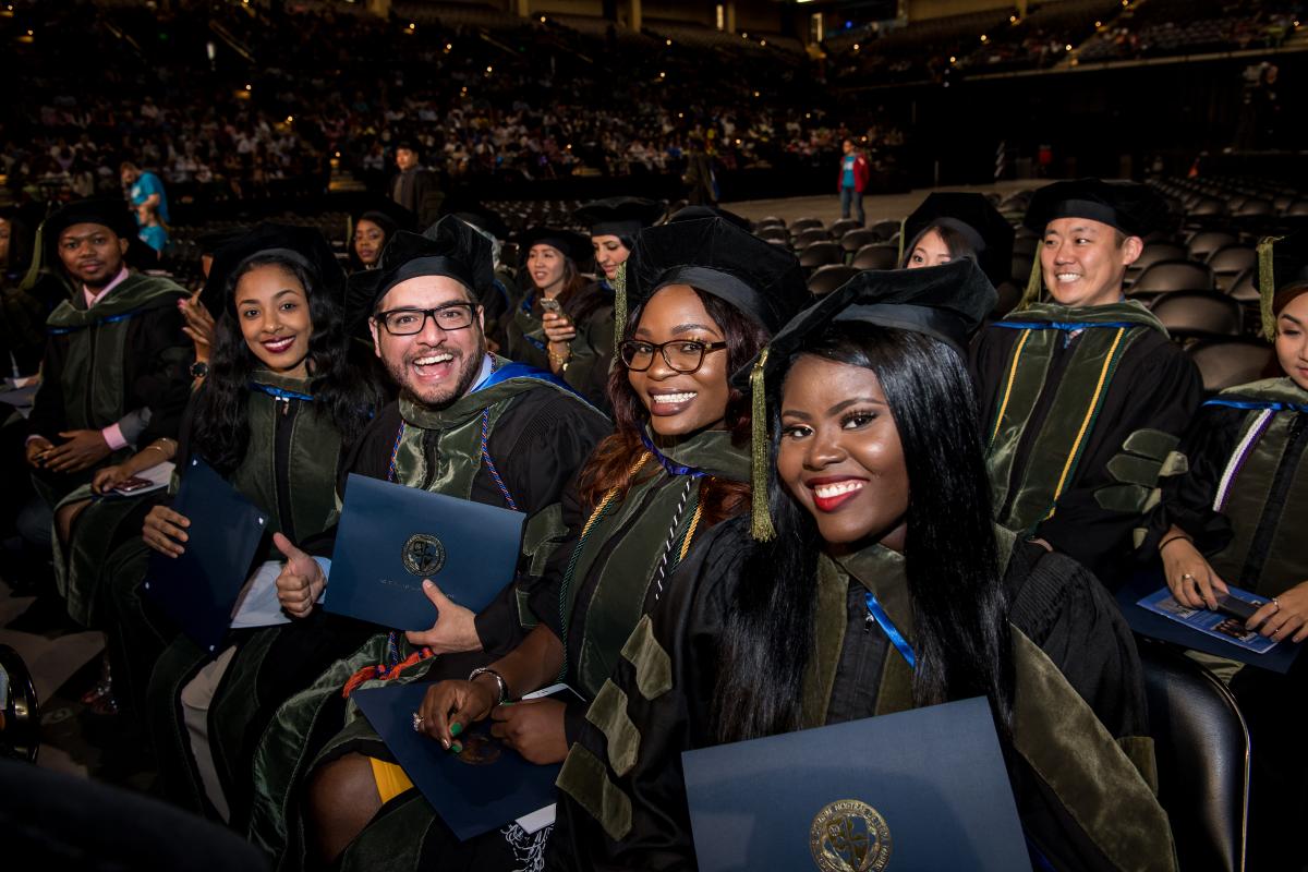 Graduates holding their diplomas at Commencement