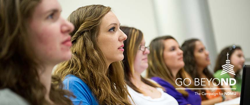 Six women sit in a classroom