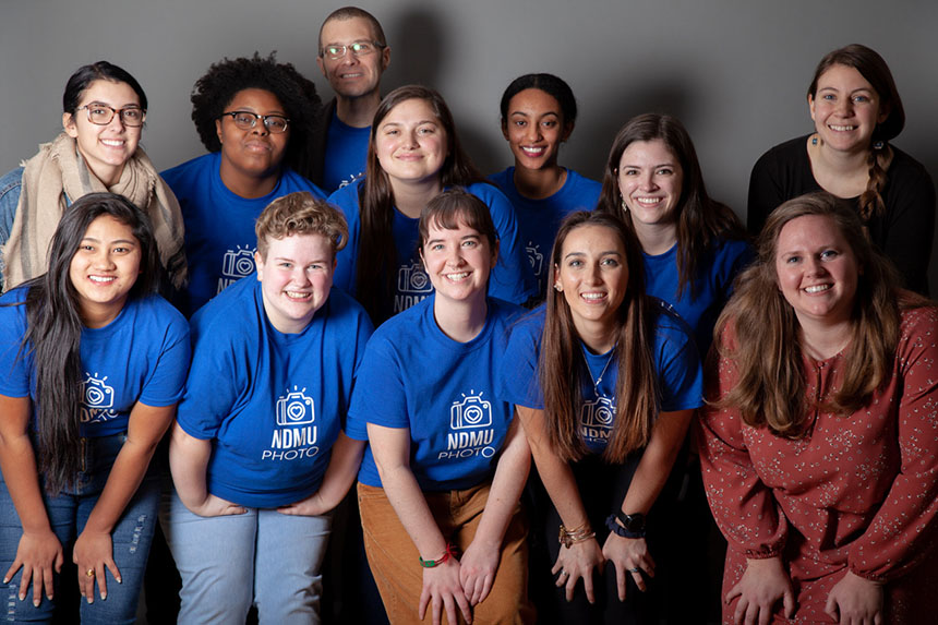 Students in Professor Geoff Delanoy’s class on portraits and photography pose after a service-learning event at Asylee Women Enterprise