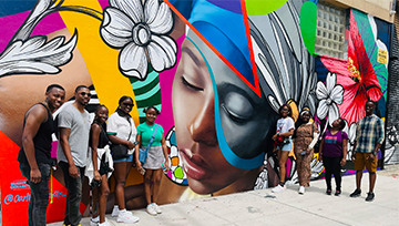 a group of people in front of painted wall