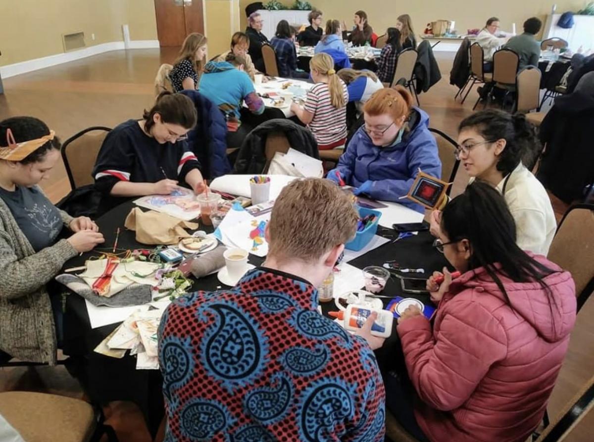 group of people participate in a group art project