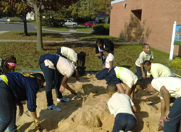 Students digging in the sand