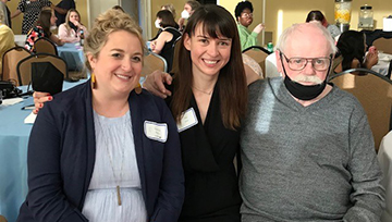 Two attendees with Gene Farrington at his retirement ceremony