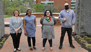 The four graduates pose near the NDMU archway