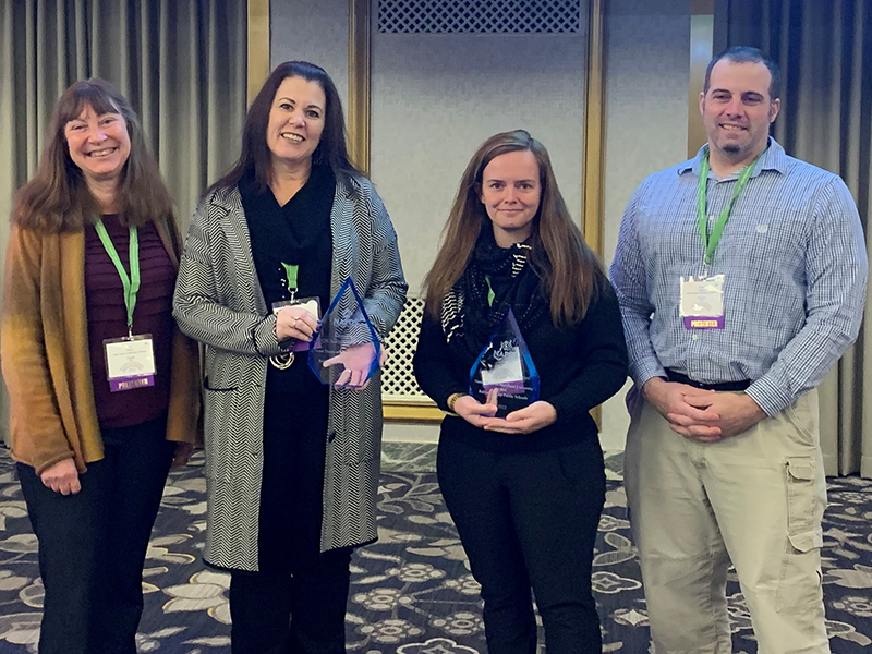 Four members of Notre Dame's PDS program pose with the award.