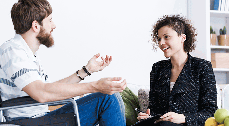 Female Occupational Therapist talking to a male client in a wheelchair