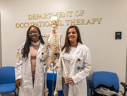 two students holding a skeleton