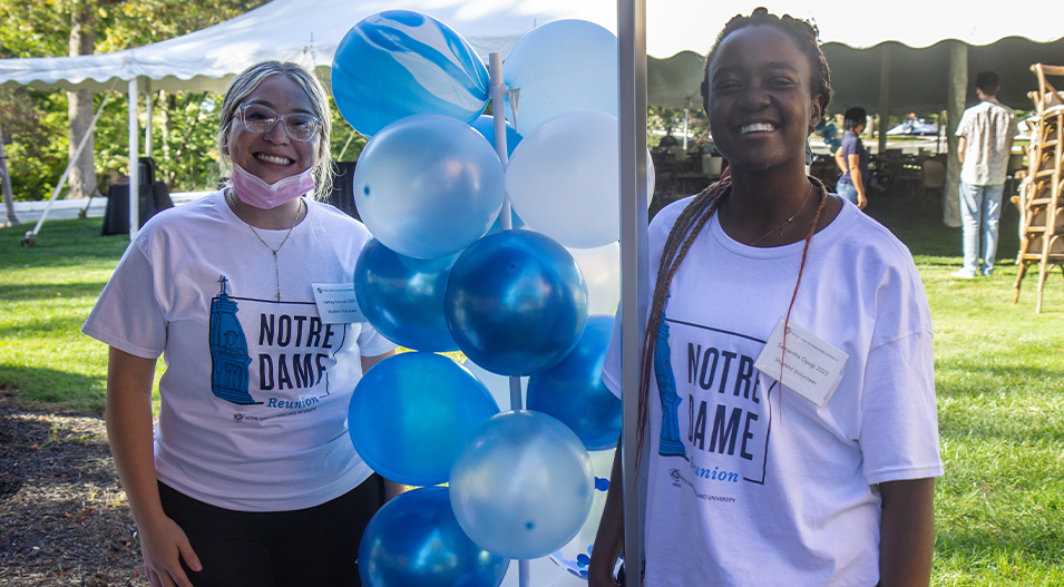 Student volunteers next to balloons