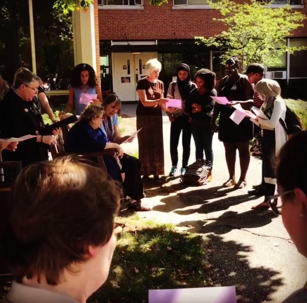 Wide shot of the peace pole prayer service