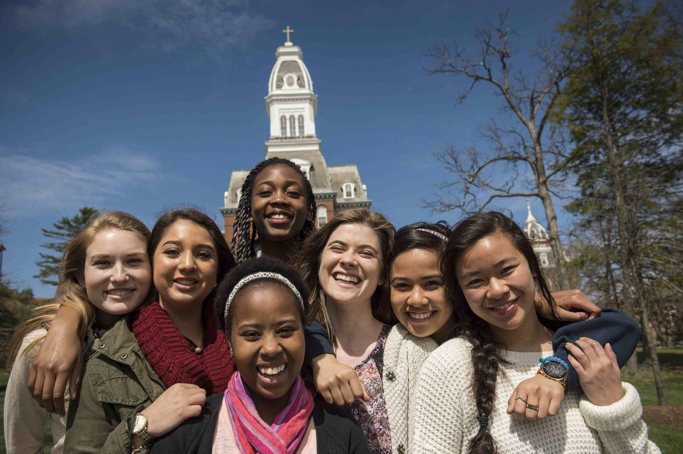 Group of female students smiling in front of Gibbons Hall