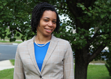 McDonald headshot in tan blazer and blue top outside.