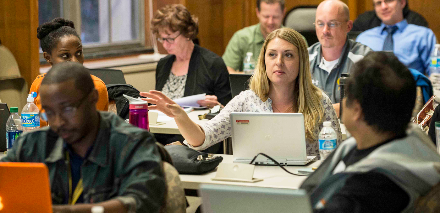 Classroom of adults with a student asking a question