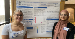 Two female students presenting a poster