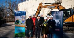 Group shot of NDMU and Brightview officials in front of construction equipment