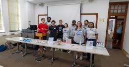 A group of students wearing NDMU gear stand in a line and smile