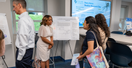 Male student presents his research to an audience while standing at a podium
