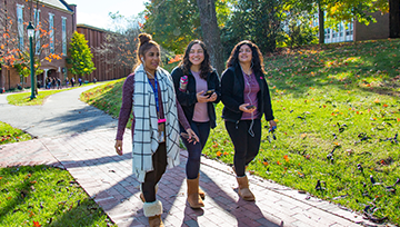 3 students walking across campus