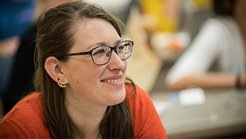 woman with glasses smiling in a classroom