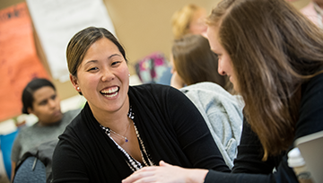 woman smiling next to a classmate in a classroom