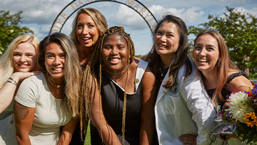 Group of nursing graduates in front of the NDMU arch