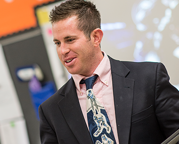 Male teacher in classroom wearing a suit and tie