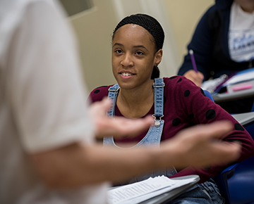 Instructor's hands explaining a concept while a student listens