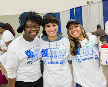 Three students at a service event in Baltimore