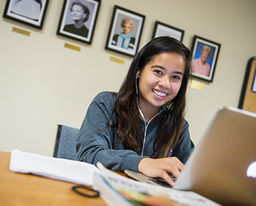 Student on a laptop smiling