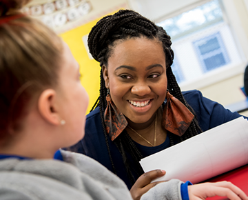 Teaching intern smiling at a young student