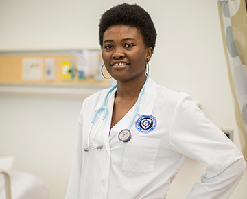 Nursing student wearing nursing attire in a sim lab