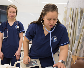 Nursing students checking on a SIM patient