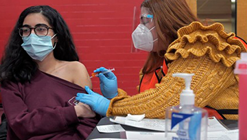 Pharmacist giving a woman a vaccine