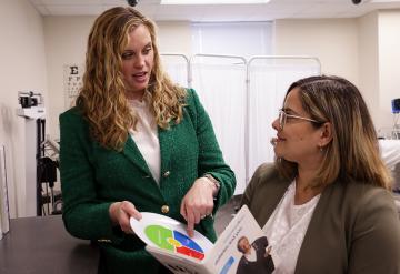 Dr. Ashley Moody and NDMU student Neysa Rios look over pharmacy material in a classroom.