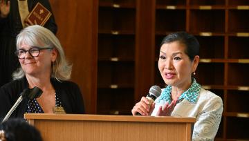 Julia Andersen and Yumi Hogan stand at a podium