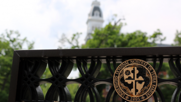 Top of sign with presidential seal with blurred Gibbons tower in the background