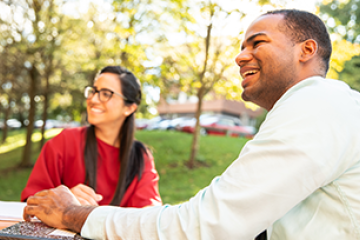 female and male professional students outside on campus