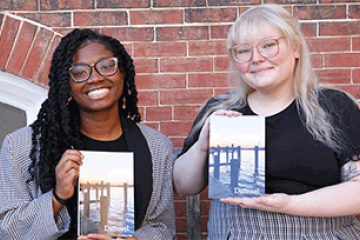 Two students holding up printed copies of Damozel