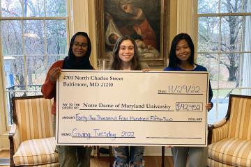 students holding a giant check