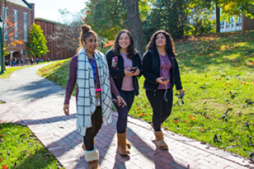 3 students walking across campus