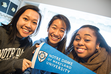 Students holding an NDMU pennant