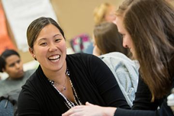 woman smiling next to a classmate in a classroom