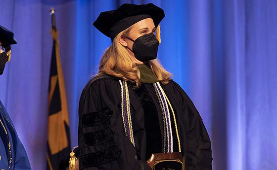 Dr. Moody holds the Mullan Award plaque at NDMU's commencement ceremony