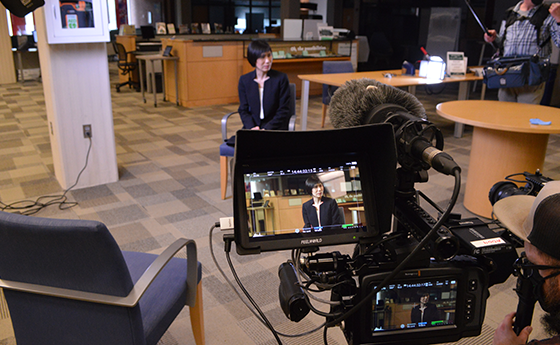 Dean Anne Lin sits in front of a camera before her an interview in the library
