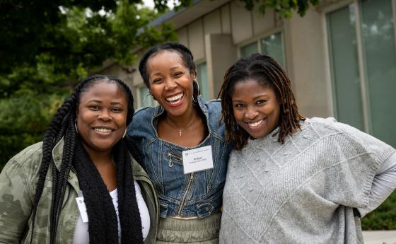three alums smiling 
