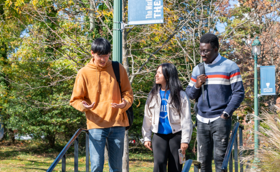 Three students walking across campus