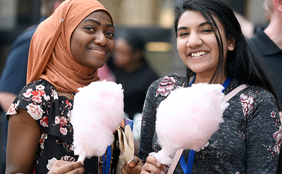 Two students smiling and holding cotton candy